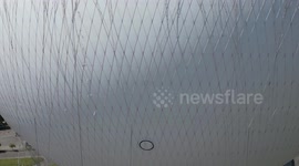 A helium balloon rises near Niagara Falls, lifting its passenger basket for a stunning aerial view with the Canadian side visible in the background.