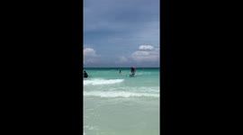 Beginner surfer crashes into toddler playing in sand