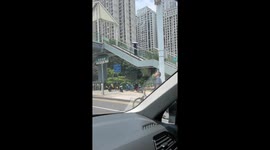 Elderly cyclist balances water bottle while overtaking in Hunan, China