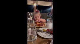 Little girl enjoys rich egg yolk on pizza in Kaonik, Bosnia and Herzegovina