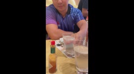 Diner pulls a face to drink from wonky glass of water