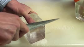 Bartender sculpts ice cube into fancy shape for cocktails