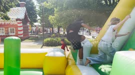 Kids playing and jumping energetically on a colorful inflatable obstacle course outdoors. Fun summer activity at a park or festival.