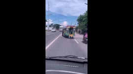Jeepney bus with a wonky wheel appears to drift along road