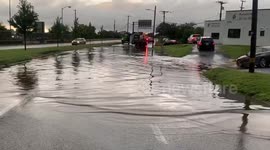 US: Car Driving On Sidewalk To Escape Flooded Street In Baltimore