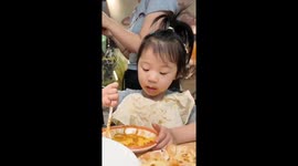 Young Chinese girl makes a mess while eating her noodles