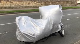 A wrapped motorcycle dances furiously to Salsa music in gale force winds, cornwall, UK