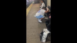 Woman casually grooms dog at Gates Ave train station in Brooklyn, New York, USA
