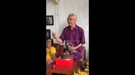 Grandfather struggles to blow out birthday cake candle