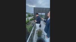 Young man attempts to open champagne but the bottle slips from his hands