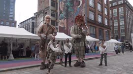 merchant city festival 2025 as giant puppets walk the street