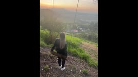 Woman flips off swing during sunset photo attempt in Penha, Santa Catarina, Brazil
