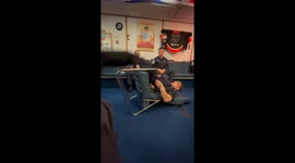 Man performs strength stunt using a chair in Portsmouth, England, UK