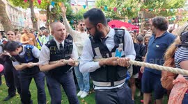The annual Firefighters Vs Policemen Tug Of War at this year's Soho Fete in Soho London
