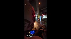 Riders help pull car from canal edge during heavy rain in Manila, Philippines
