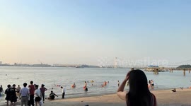 Woman slips into water but saves phone first at beach in Jiangsu, China