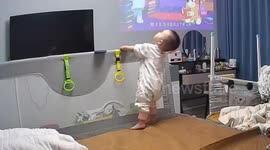 Baby topples backwards and becomes stuck behind bed