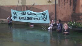 Italy: Activists Plunge Into Treviso Canal To Protest Climate Inaction With Fiery Banner