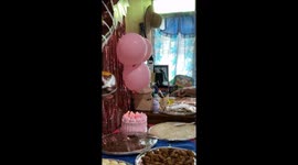 Impatient girl puts out birthday cake candle with her hand