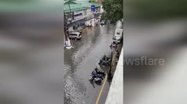 Locals wade through flooded streets in Manila
