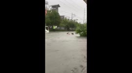 Resident carries beer bottles through neck-deep floods in the Philippines