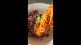 Girl makes a scrumptious pappardelle pasta with sausages and burrata