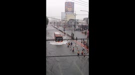 Children use flooded road as a paddling pool in the midst of a typhoon rain