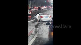 Man appears to push car through knee-deep floodwater in China