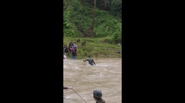 Residents wade through surging river during Typhoon Wipha evacuation
