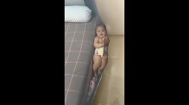 Child safely caught by mosquito net while hanging on bed edge in Shanxi, China