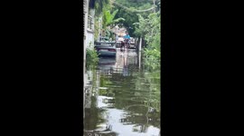 Resident uses wooden stilts to negotiate flooded roads