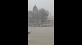 Monsoon Majesty: Tunga River Swells Beside Ancient Temple in Heavy Rain