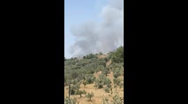 Wildfire smoke rises beyond mountains in Buca, Izmir, Turkey