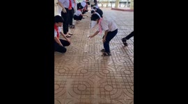 Blindfolded boy misses bottle while pouring water in Mang Den, Kon Tum Province, Vietnam