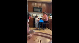 Boy helps flatten tortilla using automated press in in Oxnard, California, USA