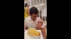 Baby adorably expects hamburger bite from dad in Santa Marta, Colombia