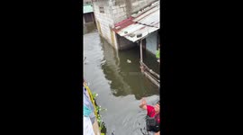 Deliveryman floats parcels on rubber ring while working through floods