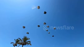 Palestinians rush to receive airdropped aid parcels in Gaza