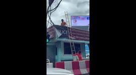 Workers repair police booth roof in their flip-flops