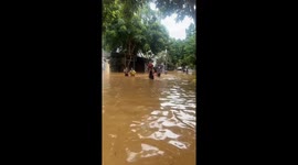 Dad carries son on shoulders through waist-deep floodwater in Vietnam
