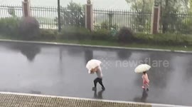Child swept by wind and rain chases after man in Hunan, China