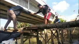 Man falls into lake after wooden bridge collapses in Batu Rusa, Indonesia