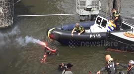 Female Protestor with flare and Palestine flag blocks booking.com boat during Amsterdam Pride Canal Parade, Police intervene