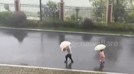 Storm blows away girl's umbrella during storm in China