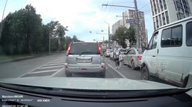 Biker lands on beggar woman when van door opens unexpectedly