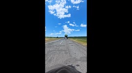 Driving a Motorcycle Under a Field Sprayer