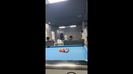 Pool player accidentally chips cue ball onto the next table