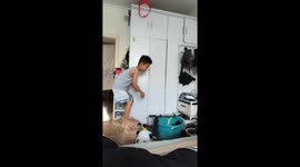 Young boy topples off chair while reaching for drum toy