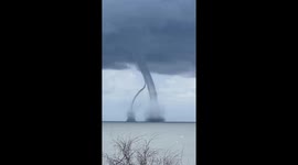 Twin waterspout tornadoes intersecting off the coast of Italy stun tourists