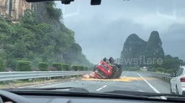 Truck driver rescued from overturned vehicle on remote road in China